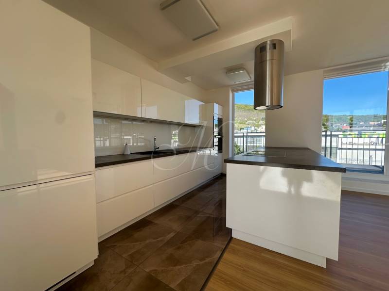 A kitchen in a 4-room apartment with light cabinets and a wood-patterned floor.