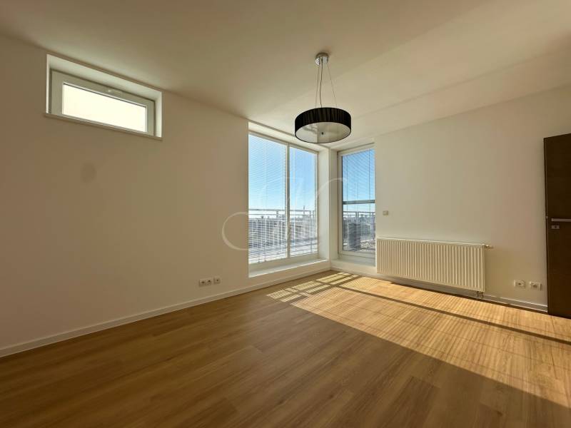 Bright room with wood-decor flooring in a 4-room apartment, large windows, radiator.