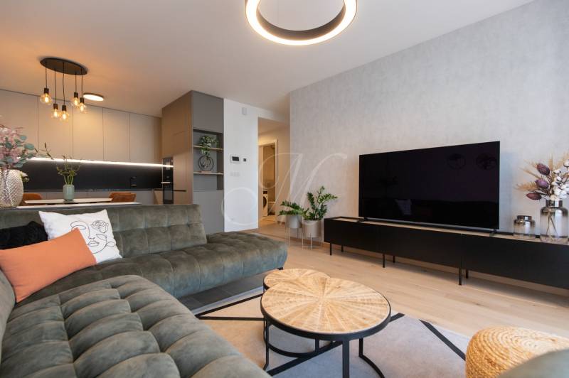 Living room in a 2-room apartment with a wooden decor floor and stylish furniture.