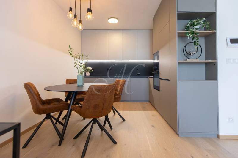 Dining area with wood-patterned flooring and stylish lighting in a 2-room apartment.