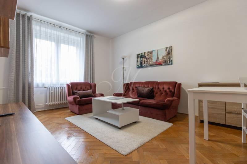 Living room with a red sofa, white table, and wooden decor flooring.