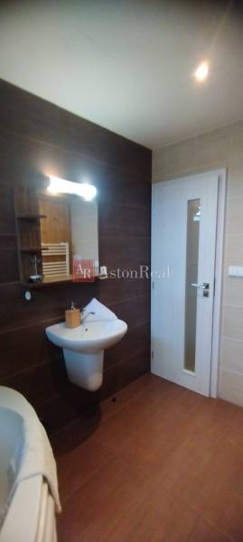 Bathroom in a 2-room apartment with a sink, mirror, and light tiles.