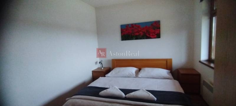 A bedroom with a double bed and wooden nightstands in a 2-room apartment.