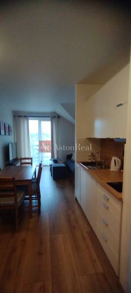 Kitchen corner and dining table with chairs, 2-room apartment, floor with wooden decor.