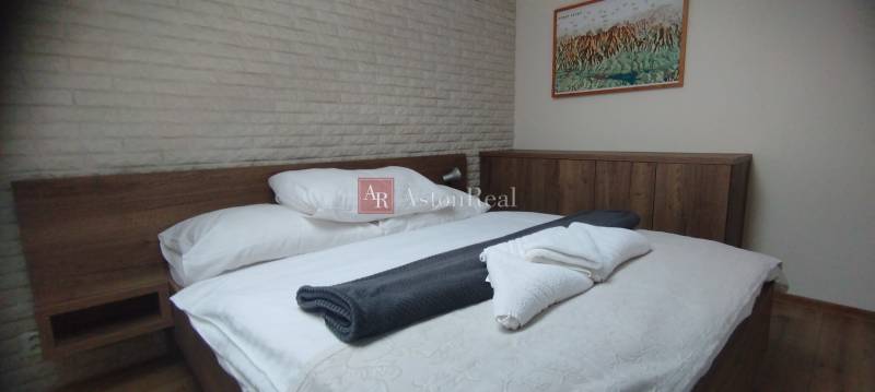 A bedroom with wooden furniture and a painting, a floor with a wooden decor, a two-room apartment.