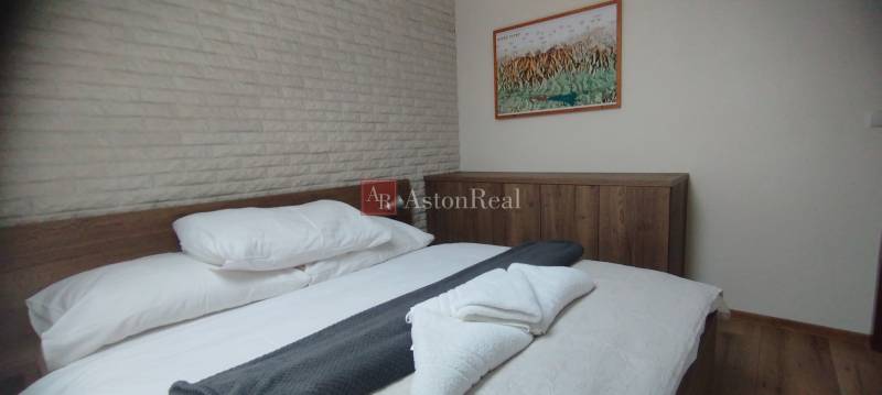 Bedroom in a 2-room apartment with a bed and a wardrobe, floor with wooden decor.