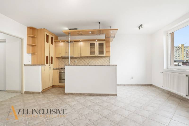 A kitchen with a corner unit in a 2-room apartment, tiled floor, white walls.