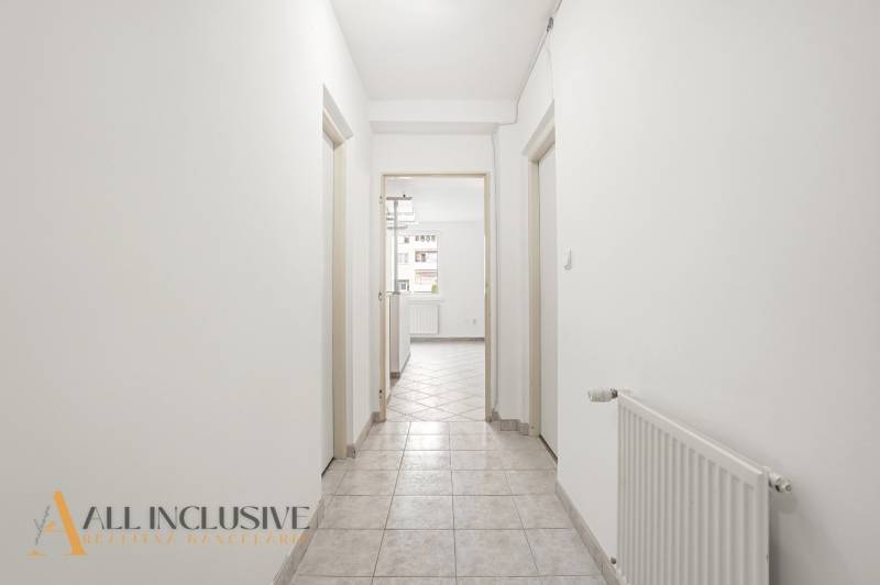 A corridor in a 2-room apartment with white walls and tiles.