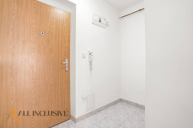 Entrance hall with white walls and tiles in a 2-room apartment.