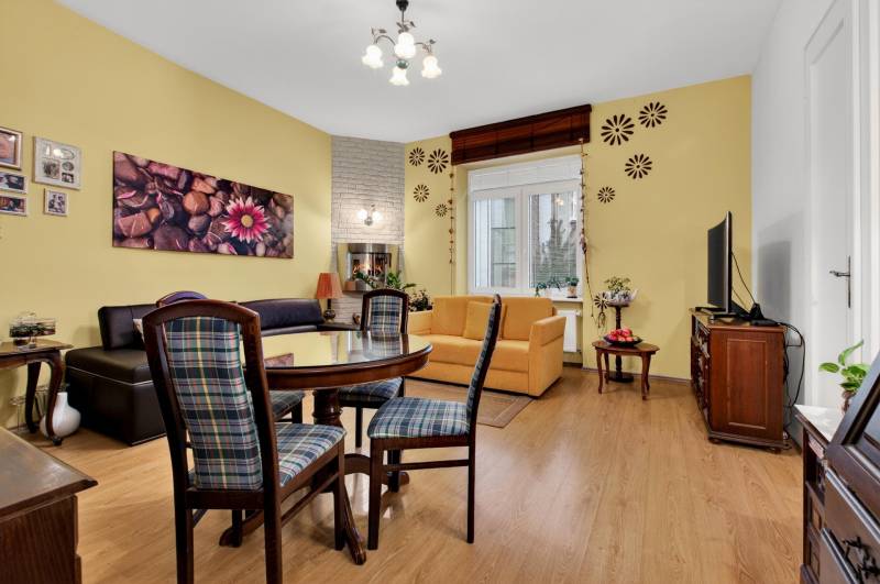Living room with comfortable seating, dining table, and wooden decor flooring in a 3-room apartment.