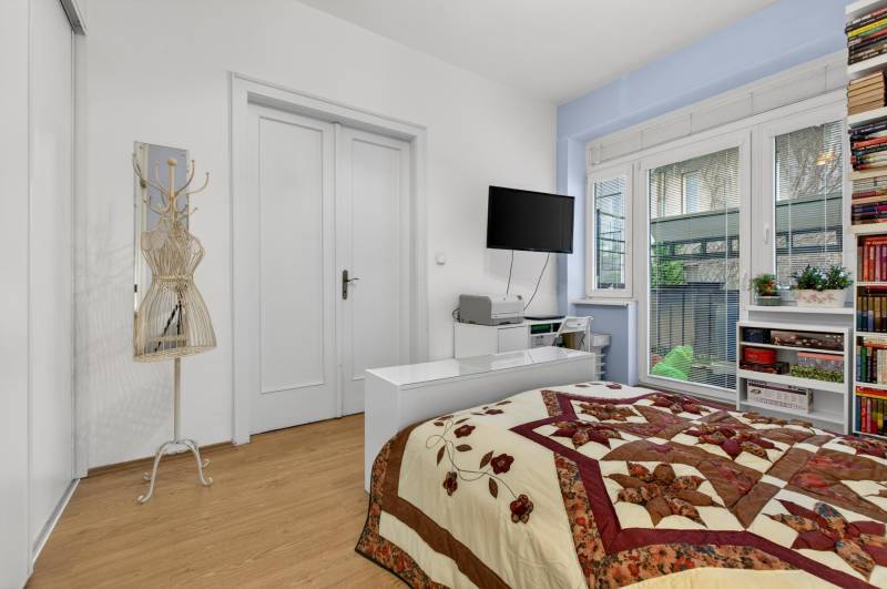Bedroom in a 3-room apartment with a bed, shelves, and a floor with a wood decor.