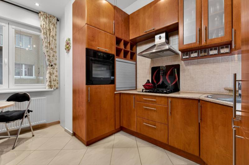 A kitchen in a 3-room apartment, equipped with wooden decor and a gas stove.
