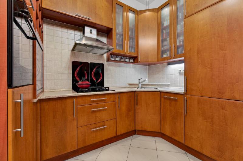 A kitchen in a 3-room apartment with wooden furniture and built-in appliances.