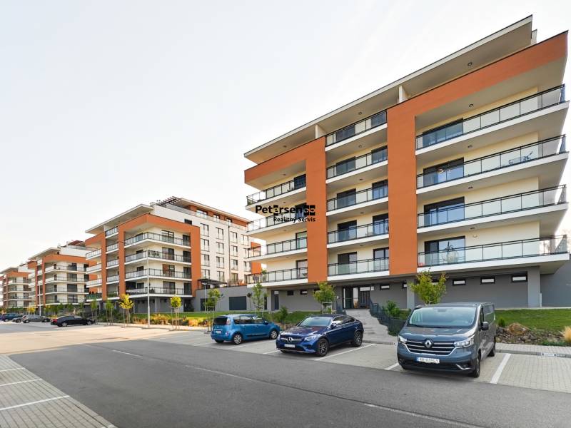 New buildings on Cedar Street in Košická Nová Ves with parking spaces in front of the buildings.
