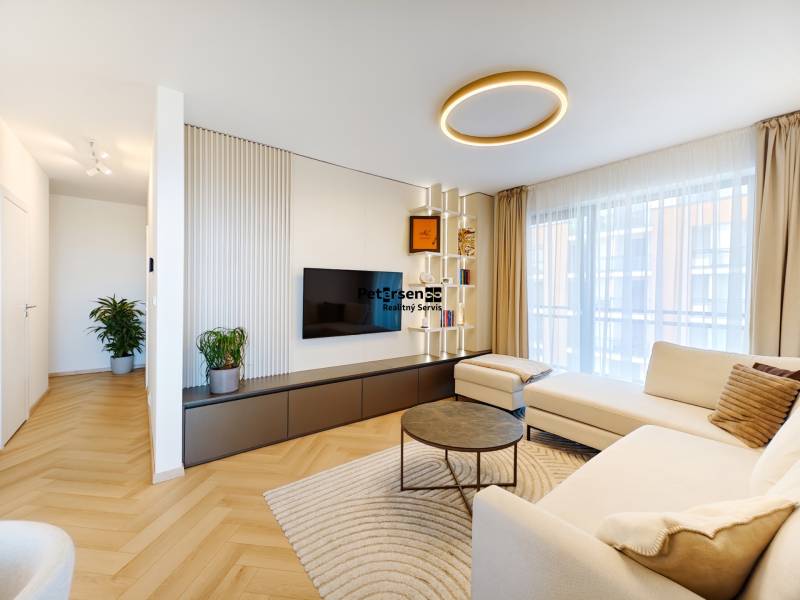 Living room in a two-room apartment with a wooden decor floor and a spacious sofa.