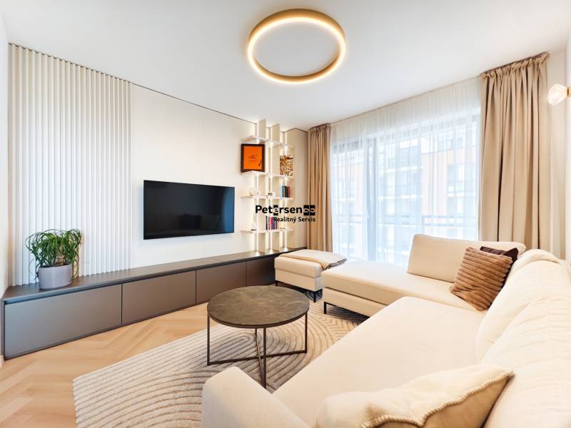 Living room in a 2-room apartment with a sofa, television, and a wooden decor floor.