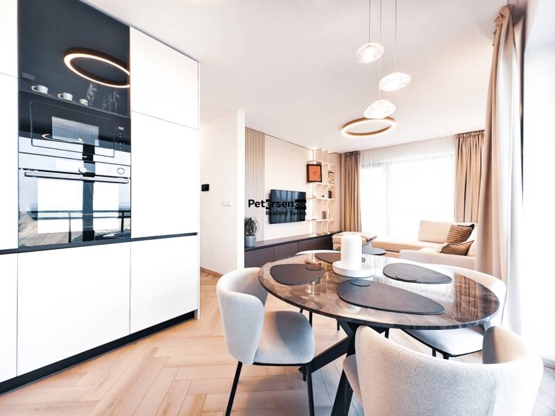 2-bedroom apartment with a dining table, sofa, and wooden decor flooring.