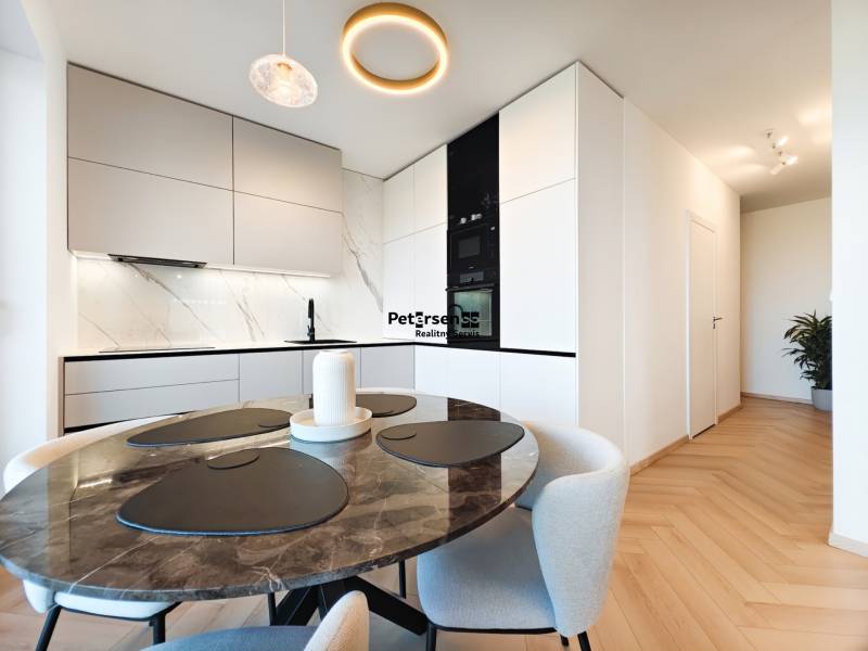 Dining area with a marble table and kitchen in a 2-room apartment, floor with wood decor.