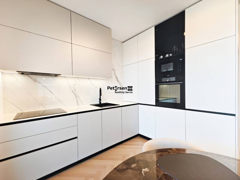 A kitchen in a 2-room apartment with white cabinets and a wood-patterned floor.