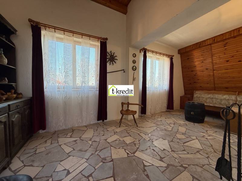 Interior of a cabin with a stone floor and stylized furniture.