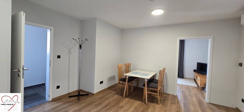Dining area with a table and chairs, wooden decor flooring in a 3-room apartment.