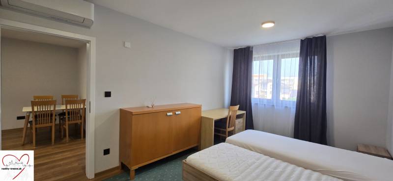 A bedroom with beds and furniture in a 3-room apartment, white walls, floor with wooden decor.