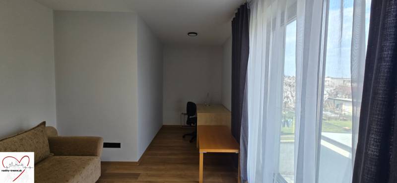 Room in a 3-room apartment with a wooden decor floor, table, and sofa.