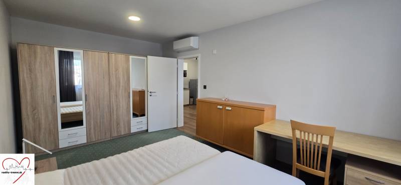 A bedroom in a 3-room apartment with a double bed, a wardrobe, and a table.