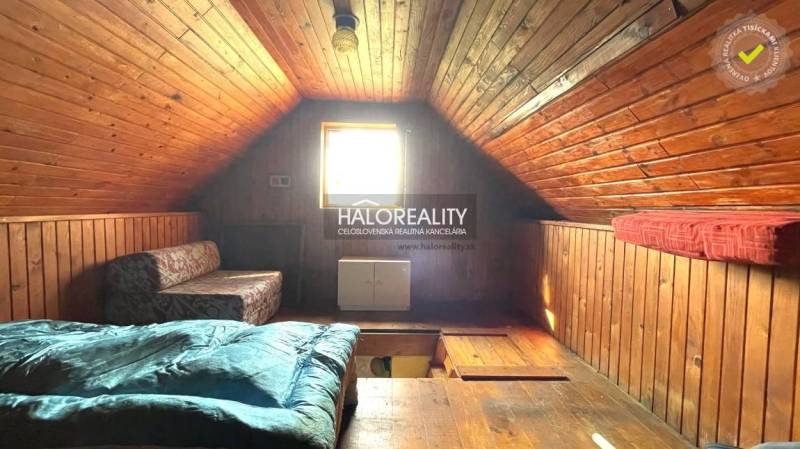 An attic room with wooden paneling, creating a cozy atmosphere, in a cabin.