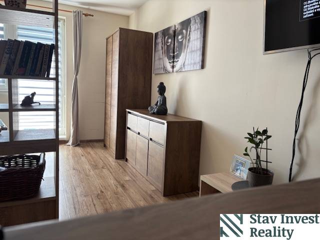 Interior of a 1-room apartment with wooden decor furniture and art on the wall.