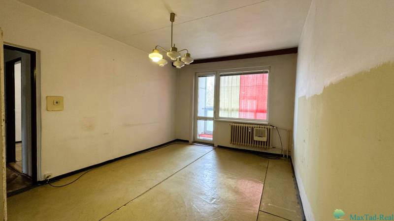 A room in a 3-room apartment with a balcony, simple walls and lighting.