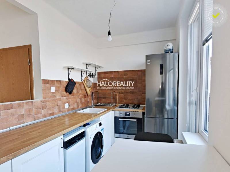 A kitchen in a 3-room apartment with a wood-patterned floor and appliances.