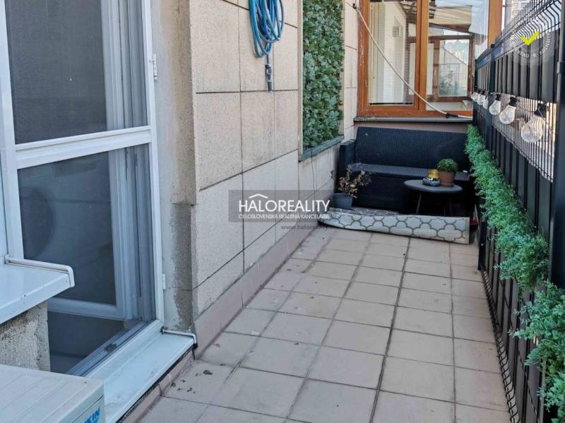 Balcony with tiles, comfortable seating, and greenery at a 3-room apartment in Bratislava - Old Town.