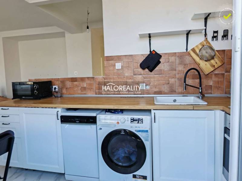 A kitchen in a 3-room apartment with white cabinets, tiles, and a wood-patterned floor.