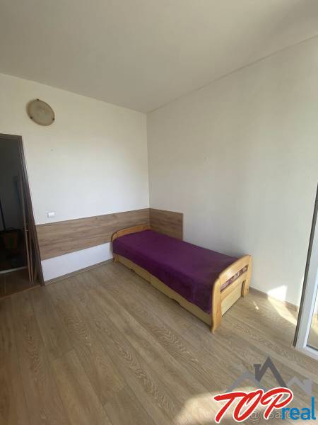 A bedroom with light furniture, a single bed, and a floor with a wooden decor in a 4-room apartment.
