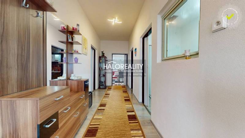 Interior of a family house with a long hallway, wooden decor flooring, and wooden furniture.