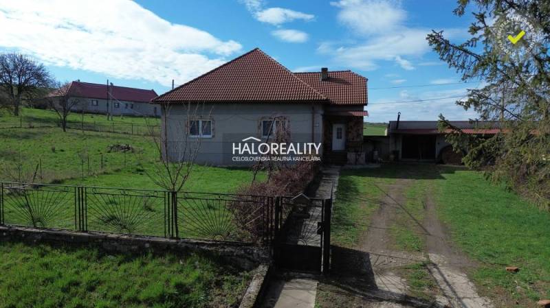 A family house in Rimavské Janovce on a plot with green lawn and fencing.