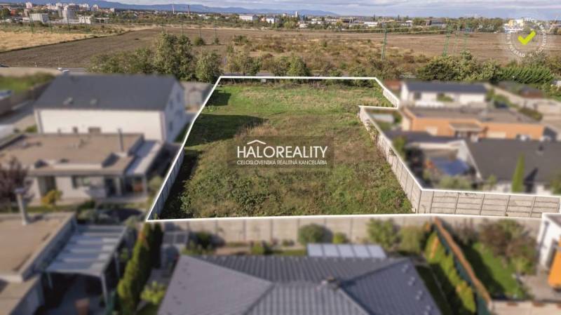 A plot of land for residential use in Senec, enclosed by a fence, suitable for building a home.