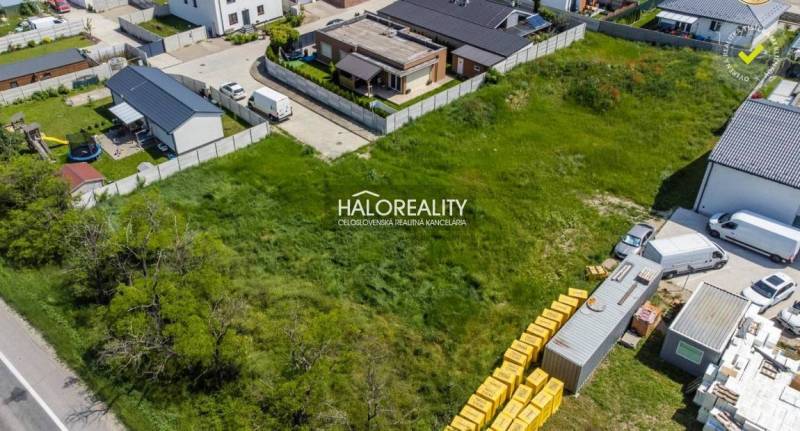 A view of a housing estate in Senec with vacant plots for housing, surrounded by buildings and roads.
