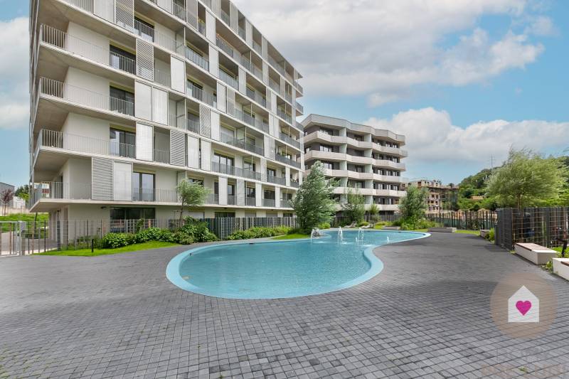 The residential area at Polianky in Bratislava-Dúbravka includes a swimming pool and modern architecture of the apartment building.
