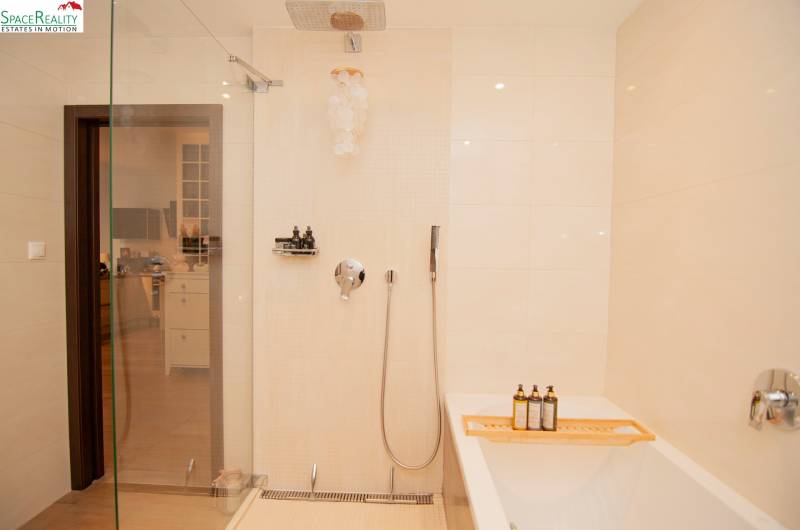 A bathroom with a bathtub, shower, and minimalist design in a 2-room apartment.
