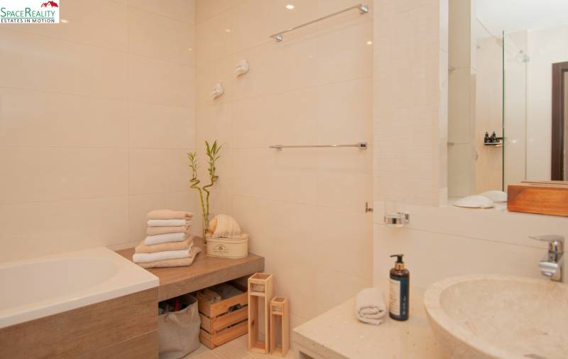 Bathroom in a 2-room apartment with a bathtub, wooden decor, and plant decorations.