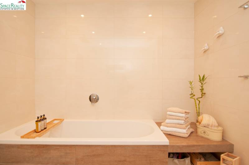 Bathroom with a bathtub, towels, bamboo decoration in a 2-room apartment.