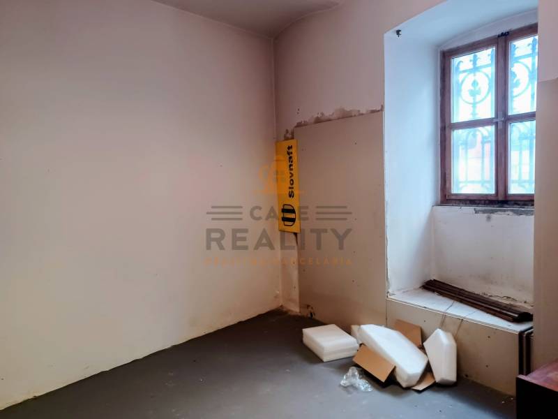 A space with plastics and boxes, with a window with bars, in commercial premises.