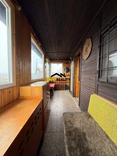 A cottage with wooden decor, cozy furniture, and large windows for a view of nature.