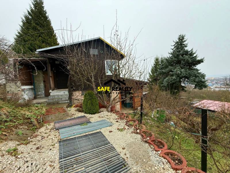 A cottage in Žilina surrounded by greenery with a view of the city.