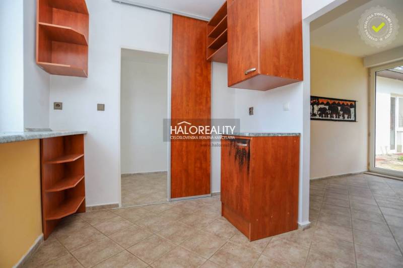 Interior of a family house with a wooden decor kitchen unit and tiled flooring.
