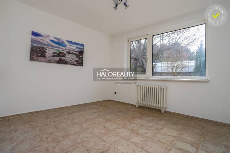 A spacious room with a window and a radiator in a family house.