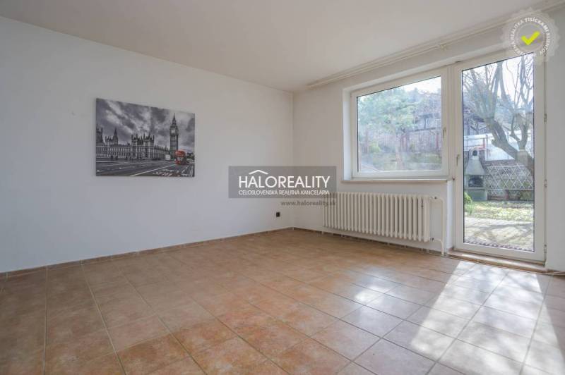 A spacious room in a family house with a ceramic floor and a large window.