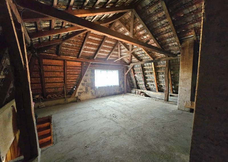 The attic of a family house with exposed roof structure and staircase.